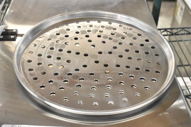 Brand new perforated metal baking pan, round, scratch and dent condition. Auction lot of 40 pans.