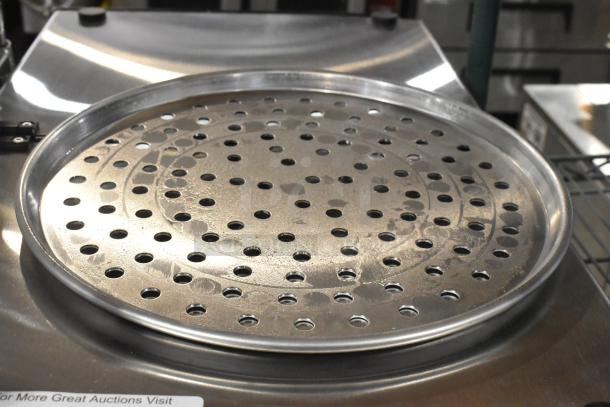 Brand new round perforated metal baking pan, scratch and dent condition, durable design, perfect for even baking.