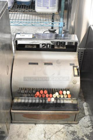 Vintage metal countertop cash register with numbered keys and visible wear. Features "Federal Cash Register Co." label.