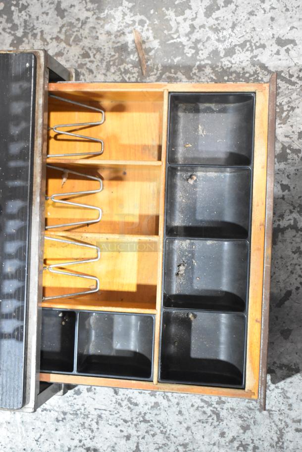 Vintage metal countertop cash register with open drawer showing coin trays and bill compartments, moderate wear.