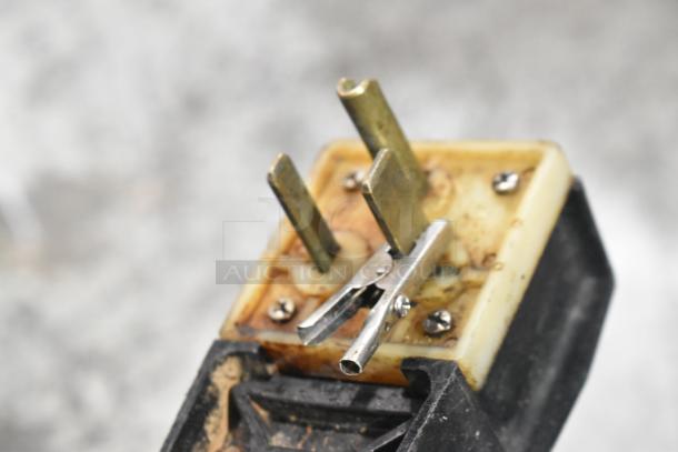 Close-up of a plug connector from a Perfect Fry Company PFA720 ventless fryer, showing metal prongs and signs of wear.