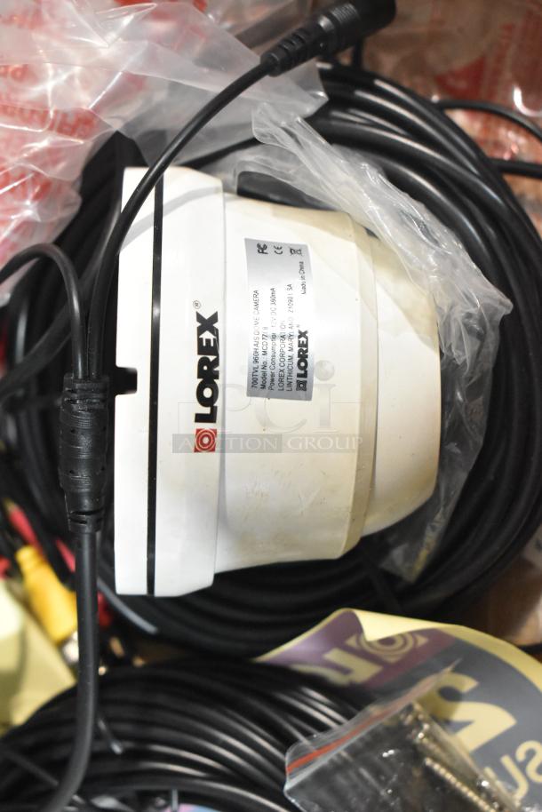Lorex LDC7708PK4B dome camera, white, includes cables and label showing model, CE, and FCC markings.
