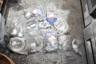 Lot of brand new scratch and dent items, including hoses and stacking kits, sealed in plastic bags, with visible labels.