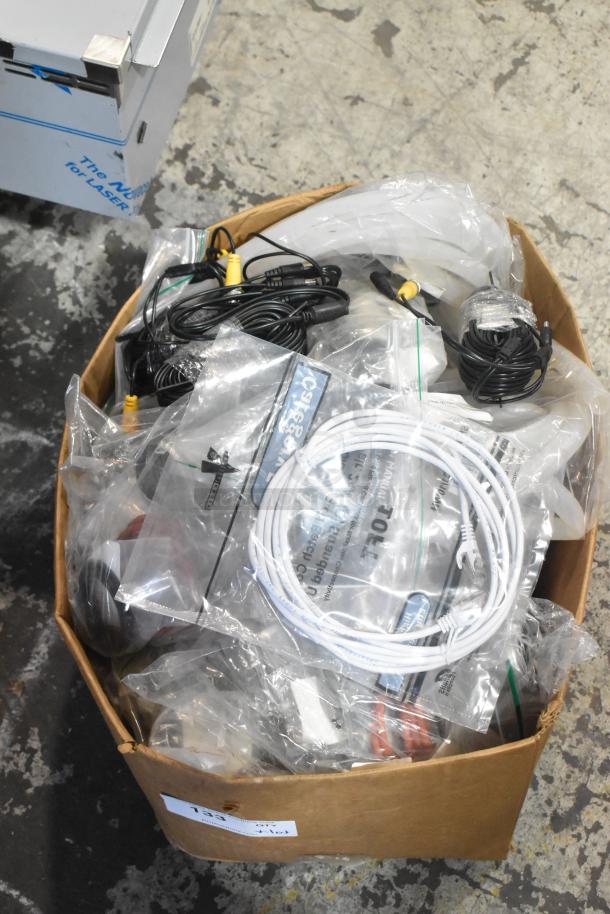 Box of assorted new scratch and dent items including hoses, stacking kits, and cables, packaged in plastic bags.