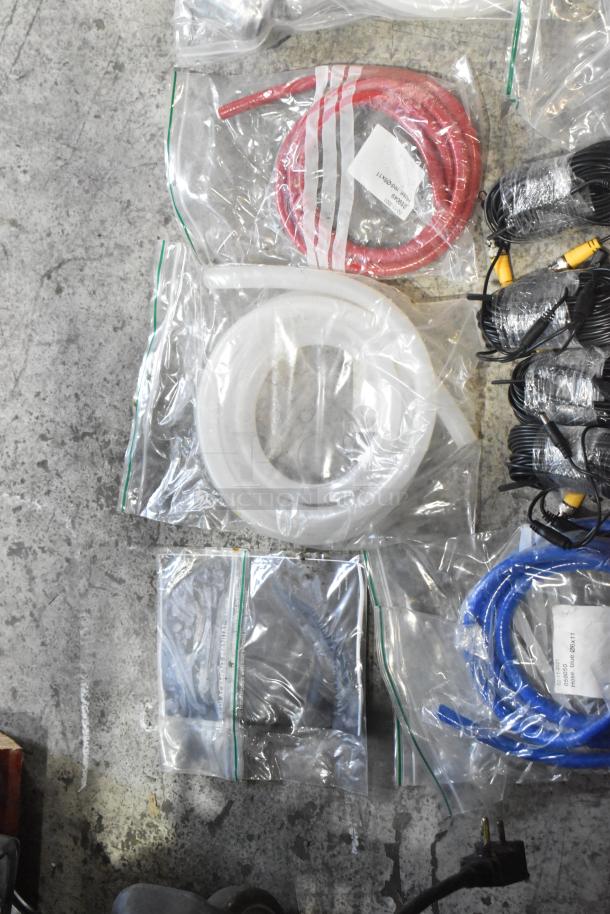 Lot of brand new scratch and dent hoses and stacking kits in clear bags, various colors, tagged with product codes.