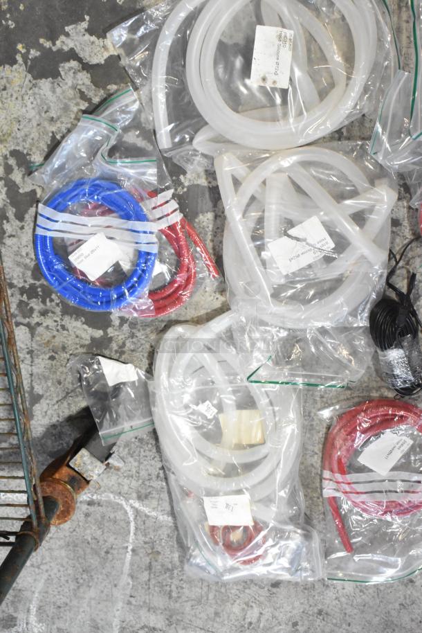 Lot of brand new hoses and stacking kits with minor scratches in sealed bags, various colors, labels visible.