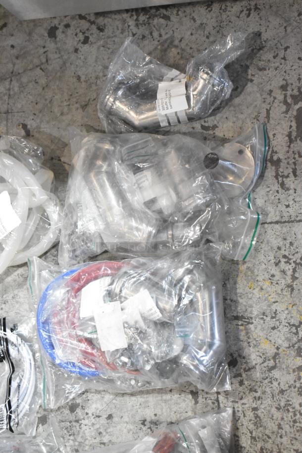 New scratch and dent lot including hoses and stacking kits in sealed bags. Contains visible labels and tags.