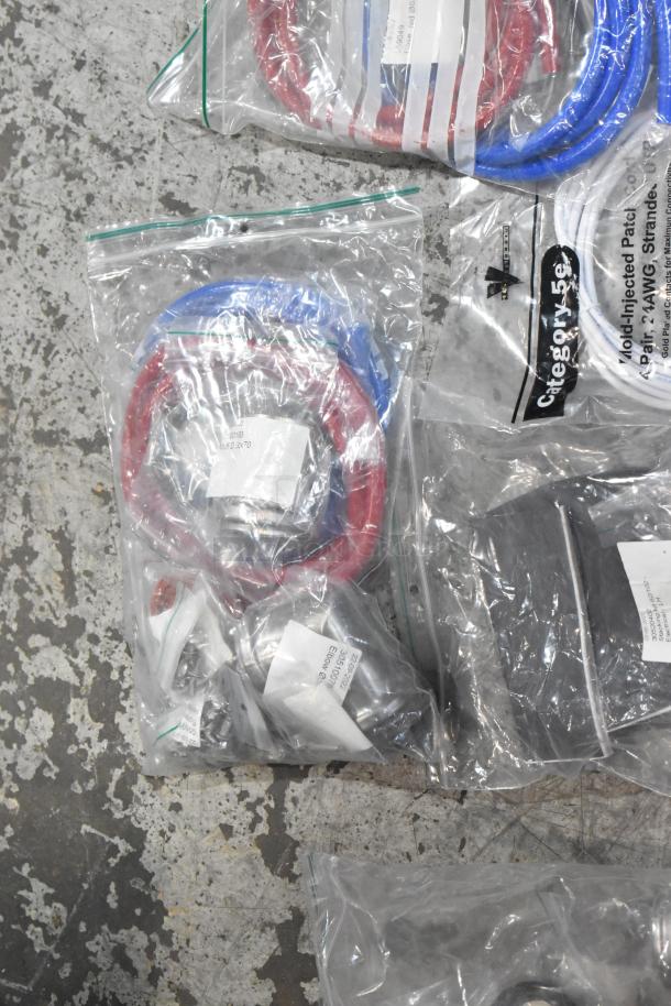 Lot of brand new scratch and dent items including red and blue hoses, stacking kits, sealed in clear bags.