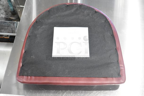 Maroon seat cushion, brand new, with visible scratch and dent. Includes visible care label. Auction offers 4 cushions.