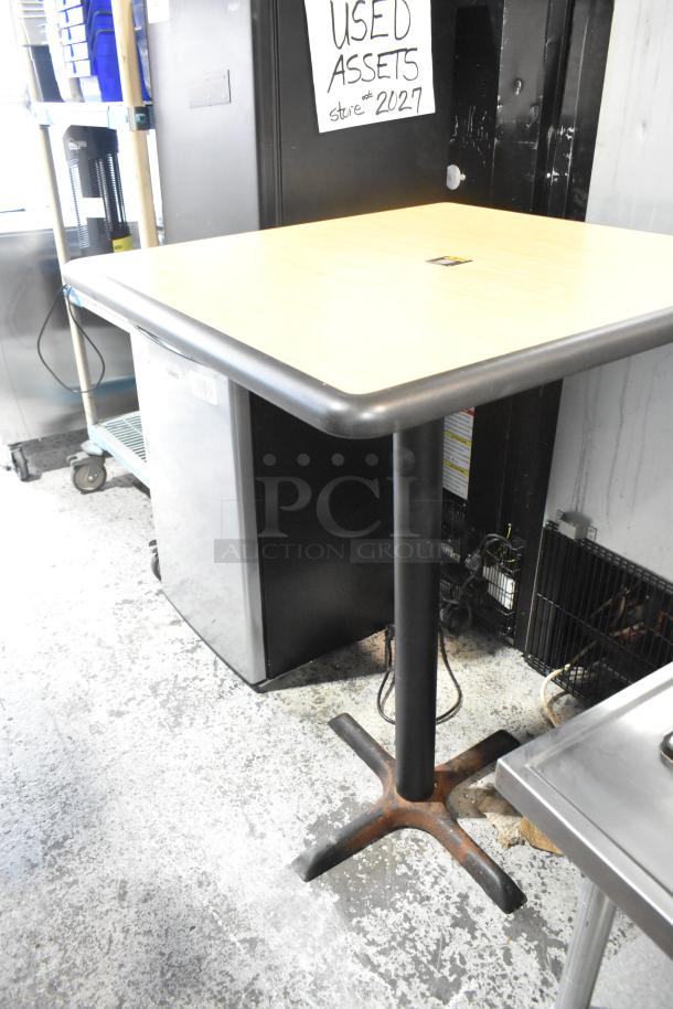 Bar height table with wood pattern top, black metal base. Good condition, ideal for modern settings. Bid doubles!