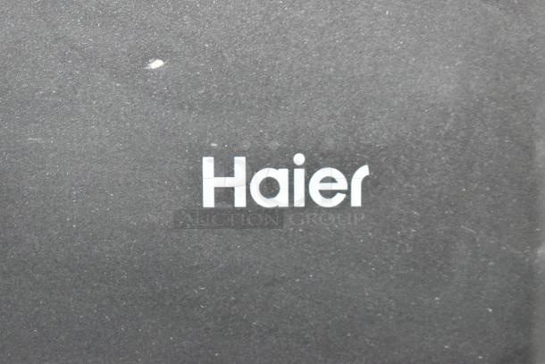 Haier HC27SF10RB Mini Cooler, black finish, featuring Haier logo. 115 Volts, 1 Phase. Minor surface wear visible.