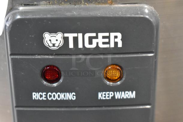 Tiger JNP-S10U rice cooker control panel, showing "Rice Cooking" and "Keep Warm" indicators. Slight wear visible.
