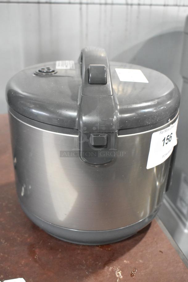 Tiger JNP-S10U rice cooker and warmer, 120V, 1 Phase, stainless steel body, visible wear, auction tag attached.