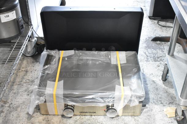 Hongtaok K23B Metal Propane Gas Flat Top Griddle, 21,000 BTU, new, wrapped in protective plastic, with control knobs visible.