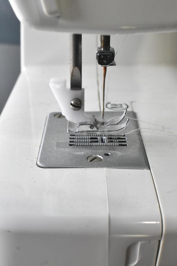 Singer countertop sewing machine with foot pedal, close-up of needle area. 120 volts, 1 phase. Visible wear, functional condition.