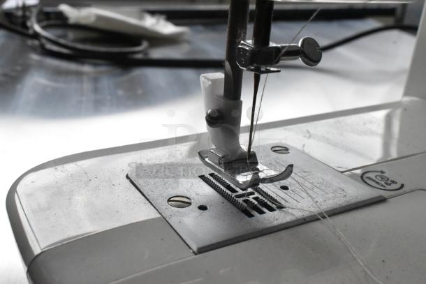 Singer countertop sewing machine with foot pedal, 120 volts, 1 phase. Visible needle assembly on metal plate, showing wear.
