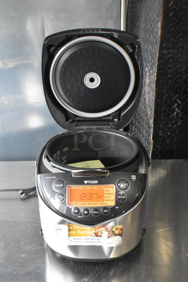 Tiger JKT-D18U rice cooker/warmer, lid does not close, 120V, digital display, various cooking settings visible.