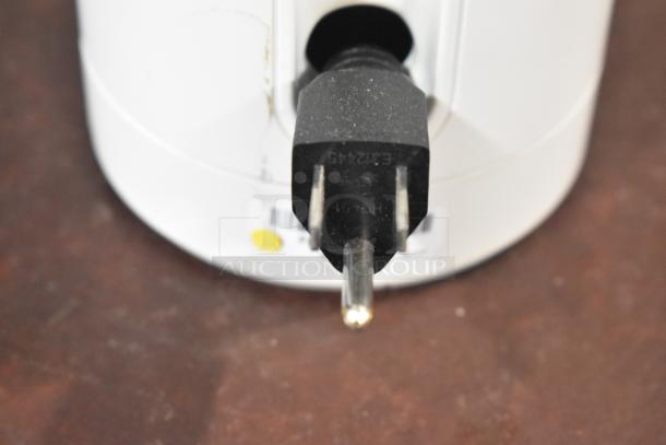 Close-up of 2024 Keurig Single Cup Coffee Maker plug, 120V, 1 Phase. Black plug with visible barcode and yellow sticker on white base.
