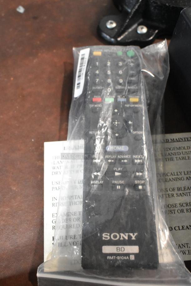 Sony BDP-S560 Blu-Ray Disc DVD Player remote in packaging. Features labeled buttons for media control. Mint condition.