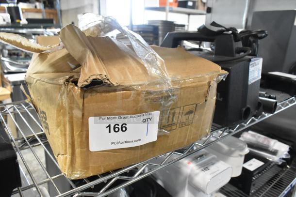 Box of cast iron pots and skillets on a shelf, damaged packaging with "166" auction label visible.