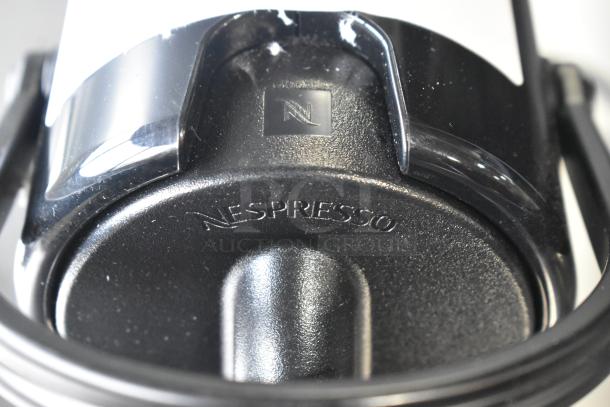 Nespresso SA single cup coffee/espresso machine, black, 120V, 1 phase, features Nespresso logo.
