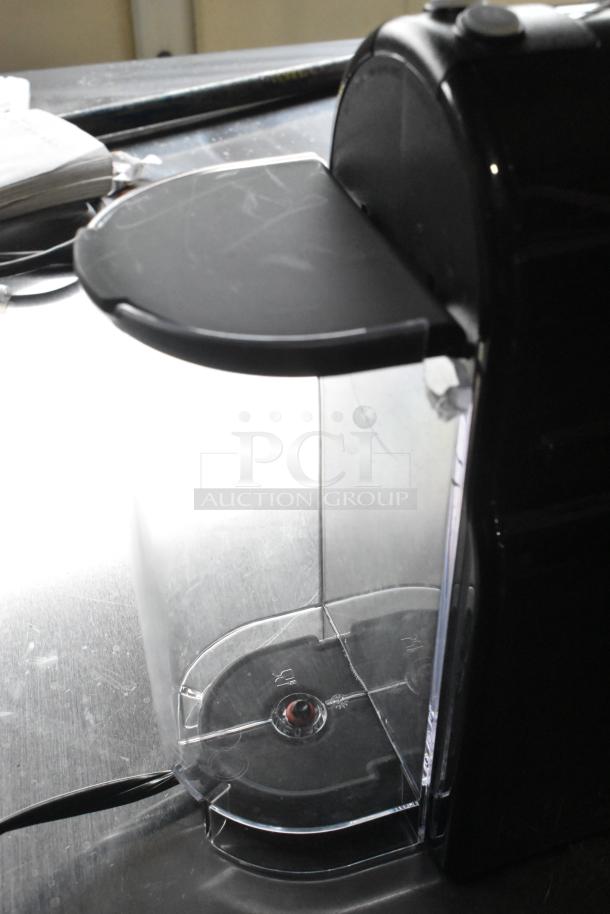 Nespresso SA single cup coffee/espresso machine, 120V, black finish, compact design; visible water tank and power cord.