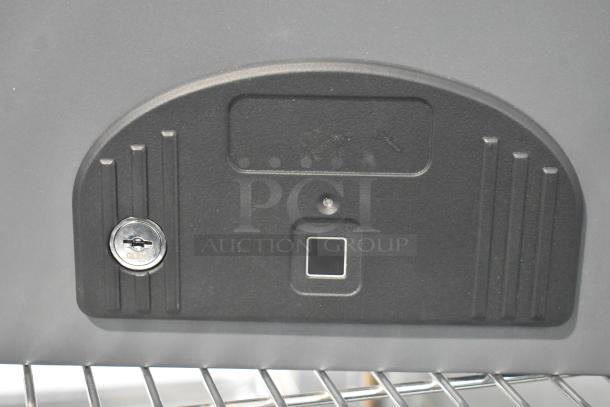 Cabela's gray metal safe with a keyhole, no keys included. Features a square indicator and textured surface.