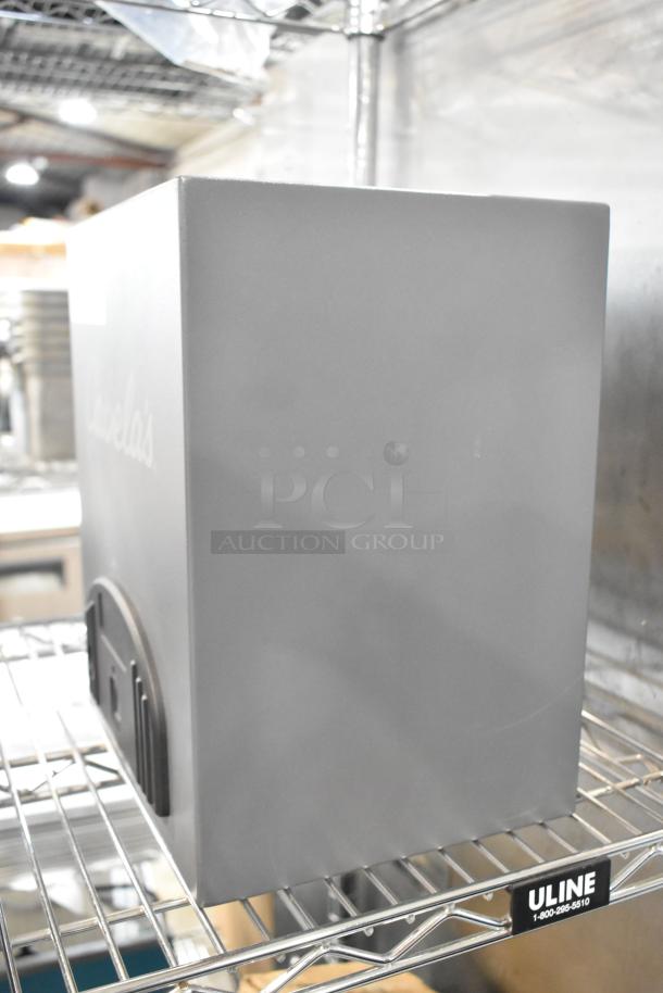 Cabela's gray metal safe on wire shelf, lacks keys, brand name faintly visible, in good condition.