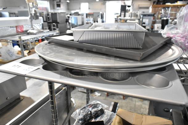 Lot of metal baking items including a muffin pan, round baking sheets, and rectangular pans. Item tag labeled "Lot 171."