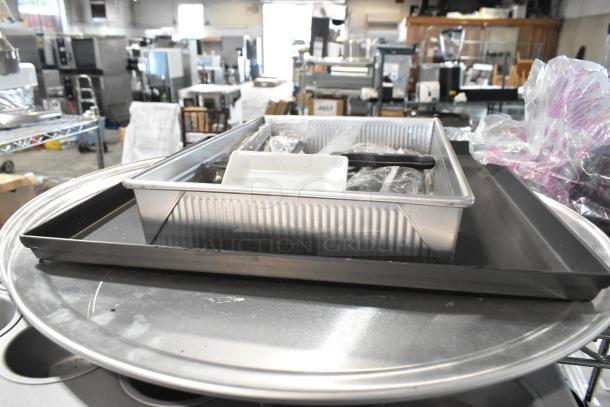 Lot of metal kitchen items including a muffin pan and round baking sheets, in good condition.