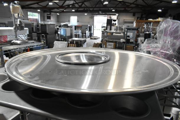 Lot of metal items featuring a muffin baking pan and round baking sheets in good condition, located in an industrial setting.