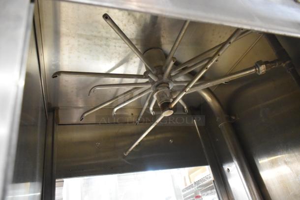 Jackson stainless steel commercial pass-through dishwasher interior, showing spray arms. Used condition, ideal for high-capacity cleaning.
