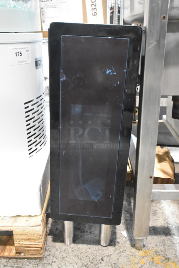 Black unit with a shiny front panel, two metal legs, and signs of wear. Suitable for industrial or commercial use.