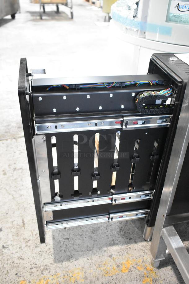 Stainless steel flavor dispenser with multiple slots, visible wiring, and sliding mechanisms. Appears in good condition.