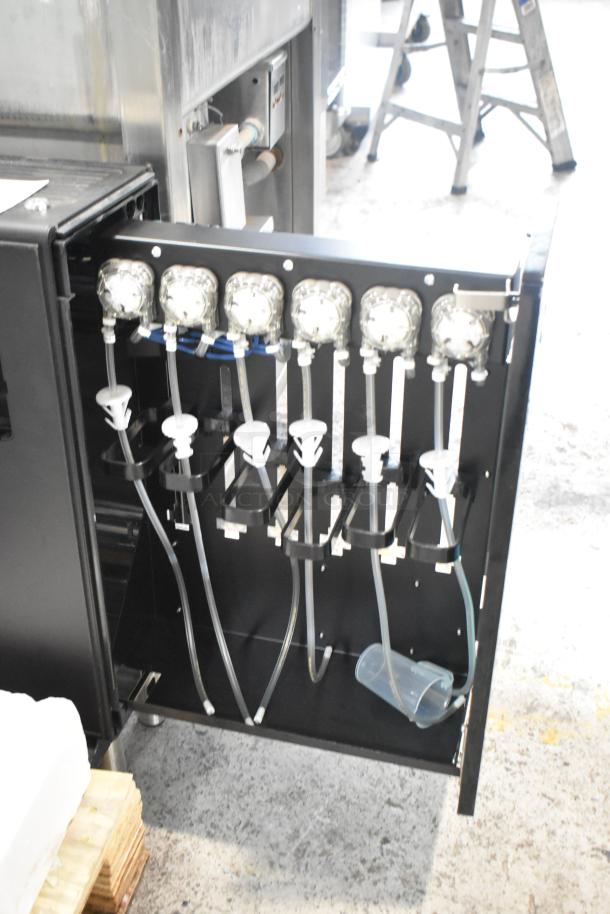 Commercial flavor dispenser with multiple dispensing nozzles and tubes, in good condition. Ideal for beverage services.