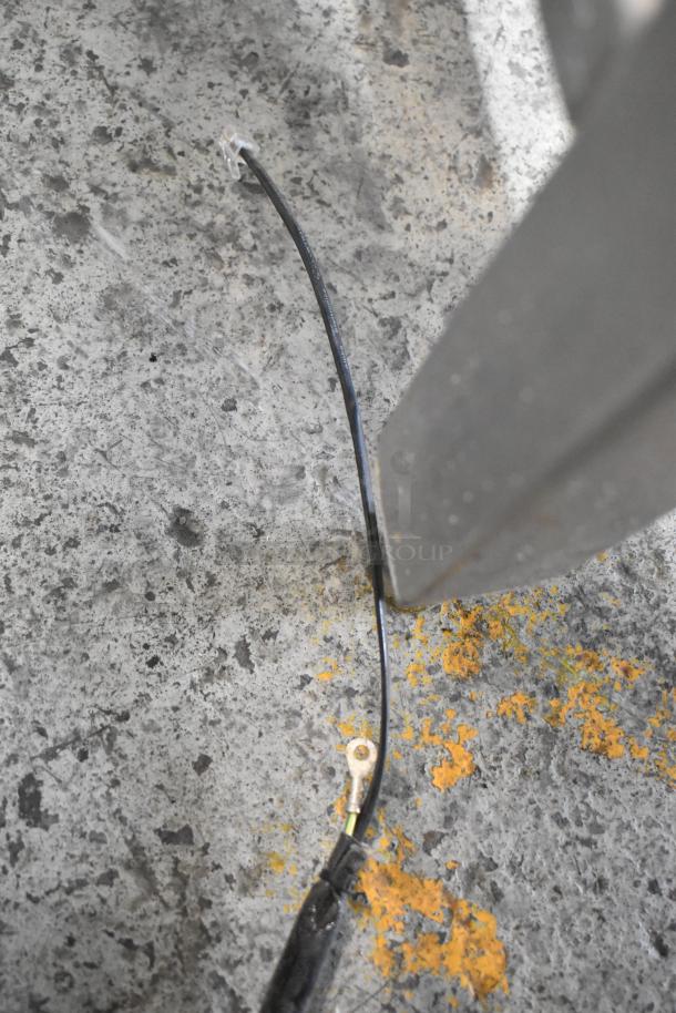 Alt text: "Industrial gray flavor dispenser on textured concrete floor with visible black cable."
