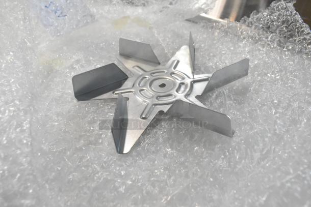 Brand new Blickman R61-120H3 fan motor on bubble wrap. Scratch and dent condition, features visible metal blades.