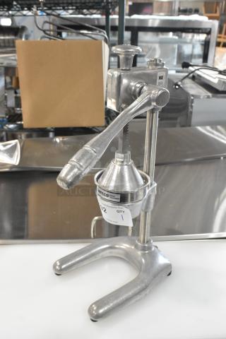 Brand new Nemco 55850 manual citrus juicer, heavy-duty metal, with minor scratches and dents; features a visible "NSE" label.