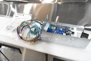 Brand new Traulsen control panel/circuit board with wiring, technical bulletins, and visible model markings.