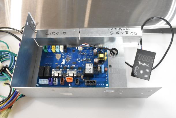 Brand new Traulsen control panel/circuit board with slight scratches. Includes various connectors and digital display. Model S54800.
