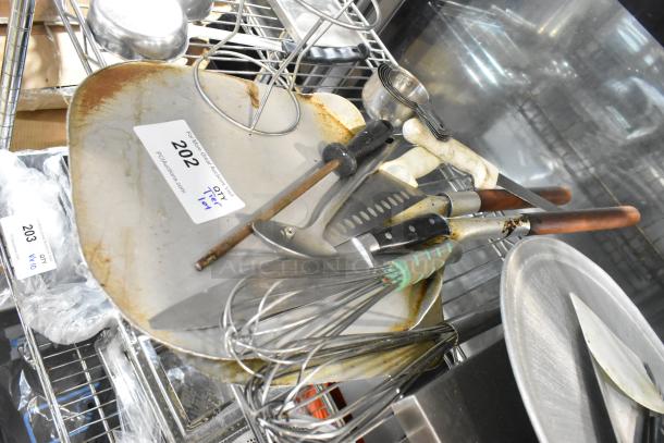 Tier lot of various kitchen items, including stainless steel drop-in bins, assorted utensils, knives, and whisks. Visible auction tags.