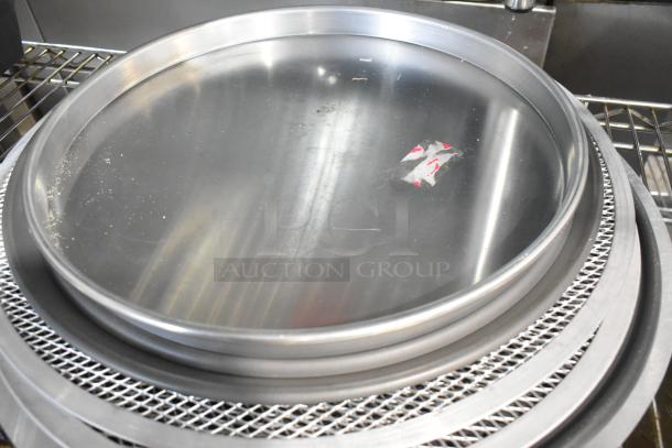 18 brand new metal mesh pans and round perforated baking sheets, some with minor scratches and dents.