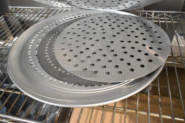 18 brand new metal mesh pans and perforated baking sheets. Scratch and dent condition. Multiple items stacked on a metal rack.