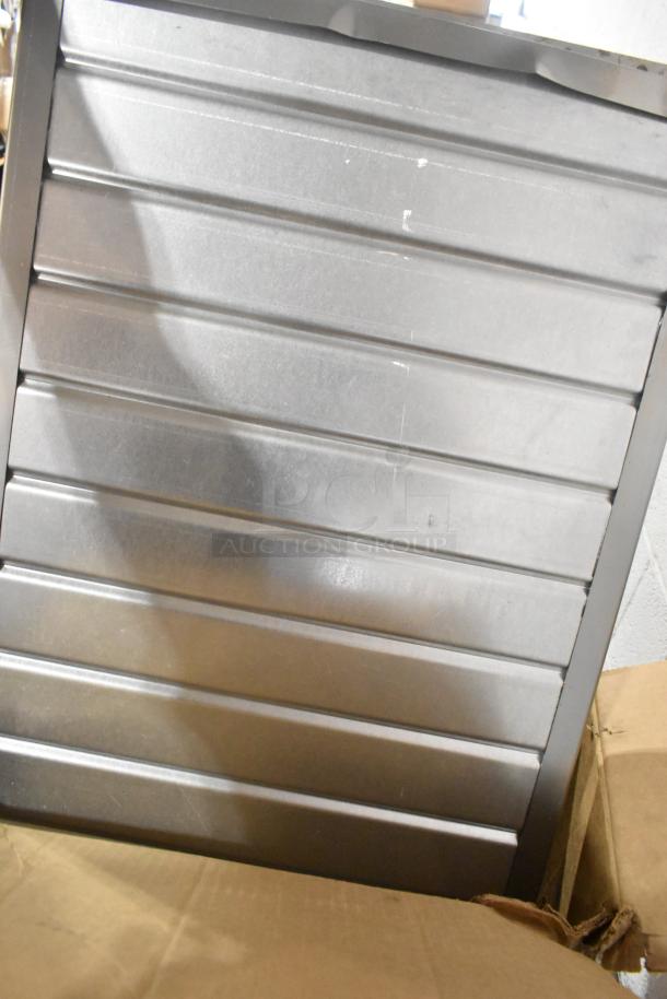 BRAND NEW Bldogett vent piece with visible scratches and dents. Shiny metal surface, packaged in a cardboard box. Ideal for HVAC use.