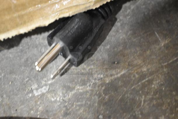 Black power plug of Bunn CW15-APS coffee brewer, shown resting on a surface.
