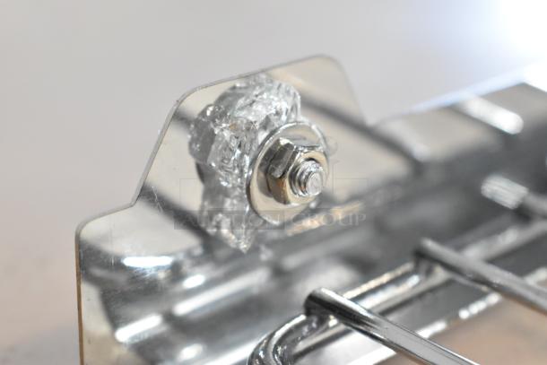 Close-up of a damaged glass section on an Avantco 177CPO16TSGL stainless steel countertop pizza oven, showing a bolt and cracked glass.