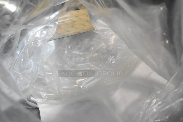 Packaging of a new Bunn BrewWISE ICB-DV coffee brewer, visible through transparent plastic wrap. Stainless steel finish.
