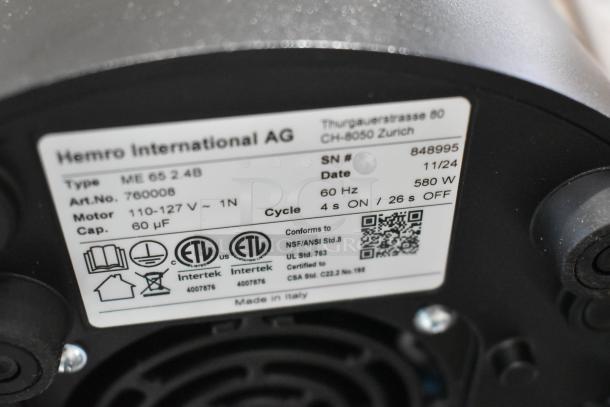 Brand new Mahlkonig E65T espresso grinder label showing model, voltage, and certifications. Minor scratches and dents.