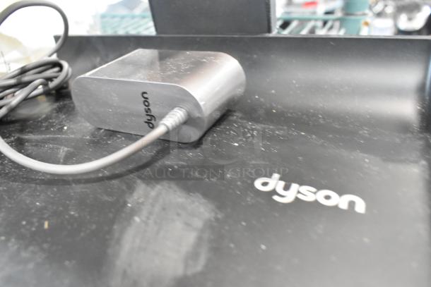 Brand new Dyson WashG1 Base with visible dust, showing "Dyson" logo. Part of 3 scratch and dent items, promising high bid value.