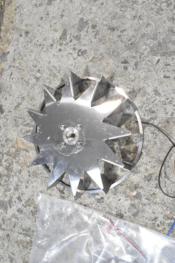 Metal component on concrete floor, featuring star-shaped blades and central bolt holes, part of scratch and dent item set.